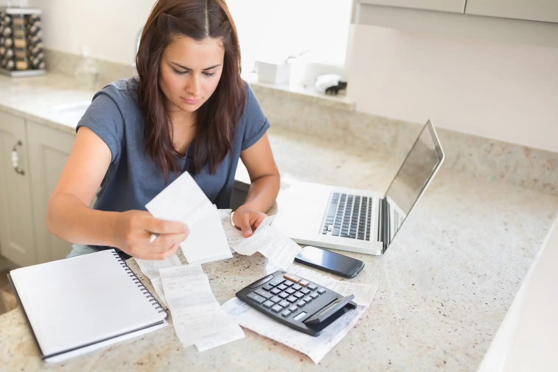 Mujer-calculando-facturas-con-laptop